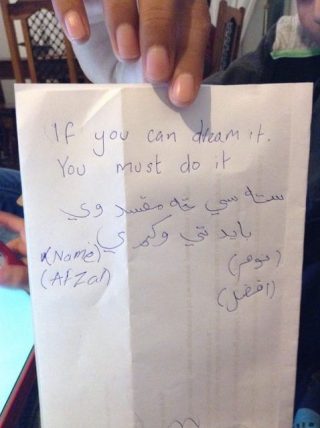 Pashto translation of 'If you can dream it, you must do it' on a piece of paper.